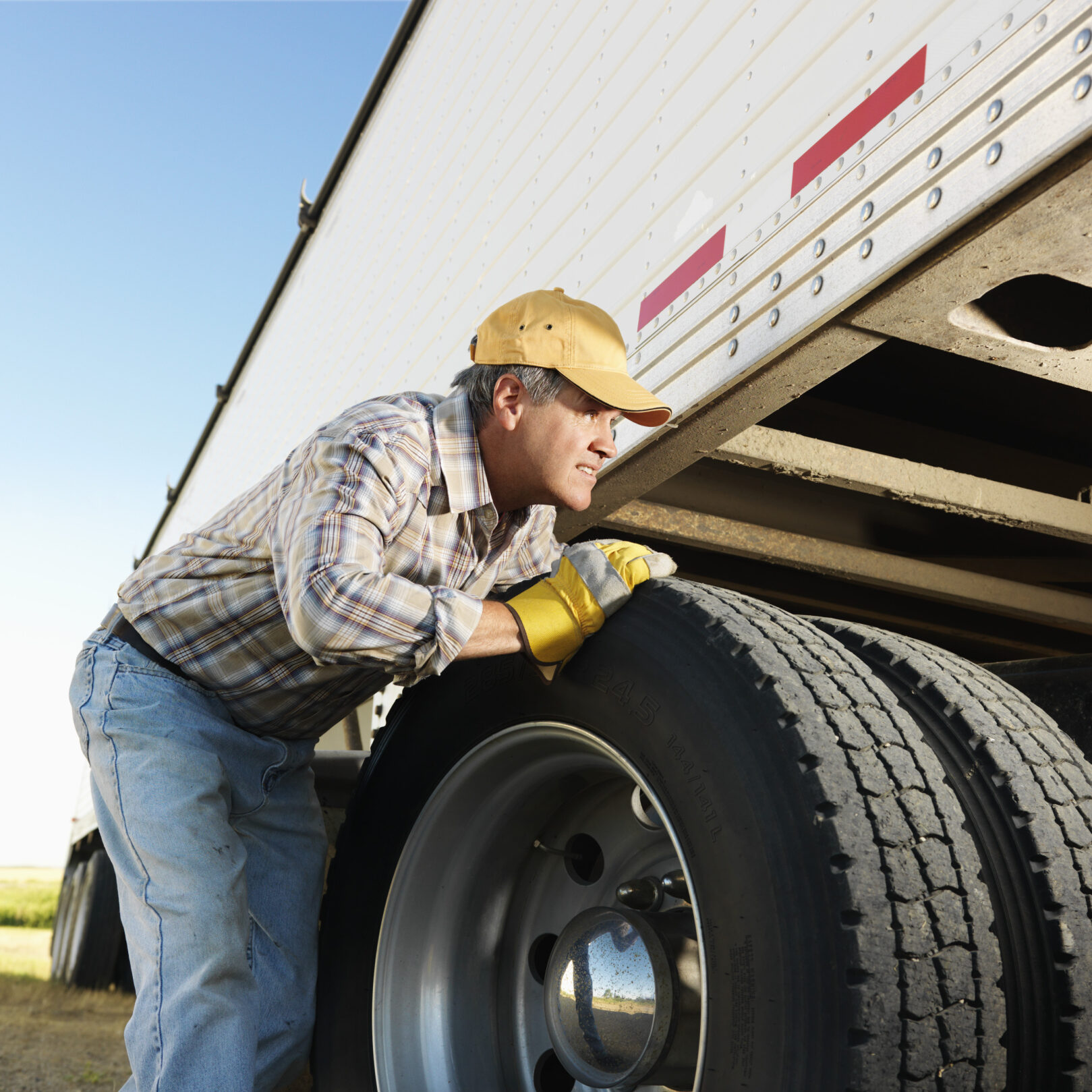 Truck Driver Looking Underneath Truck